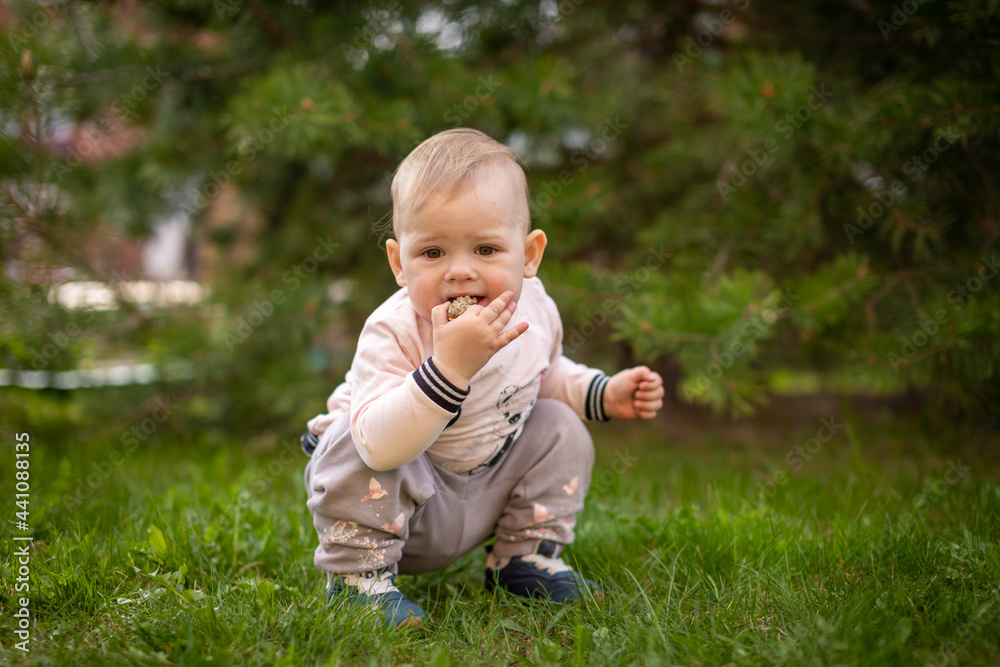 Sweet baby girl playing on green grass in park in spring time Sweet baby girl playing on green grass in park in spring time