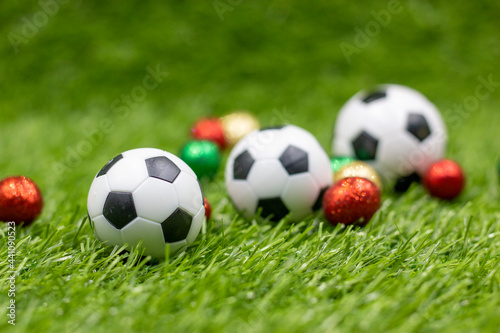 Soccer ball with Christmas Holiday decoration on green grass background