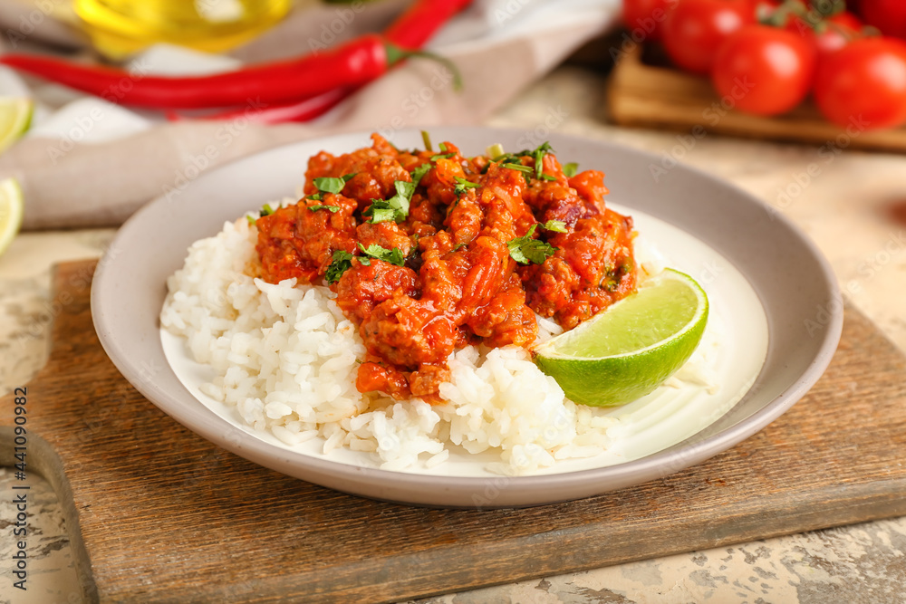 Plate with tasty chili con carne, rice and lime on table, closeup Plate with tasty chili con carne, rice and lime on table, closeup