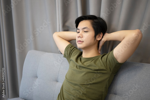 Young man resting on sofa at home.