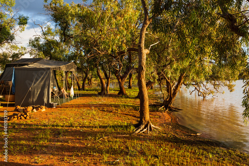 Campsite beside an outback lagoon in the early morning golden light photo