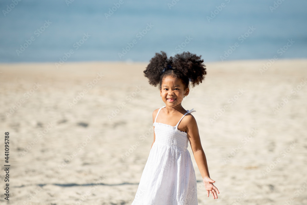 Adorable happy smiling little girl in white dress on beach vacation Adorable happy smiling little girl in white dress on beach vacation