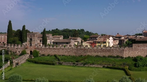 Flight over Castellaro Lagusello castle on Lagusello lake. Aerial view of the Italian medieval castle Castellaro Lagusello. Classic Italian medieval villa VILLA TACOLI ARRIGHI, Italy. photo