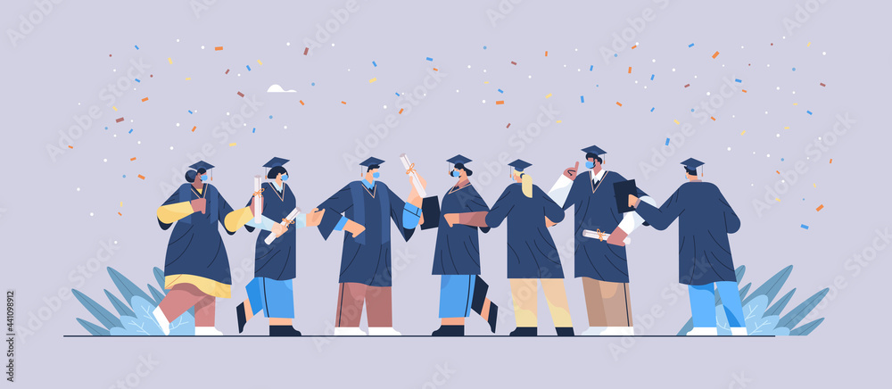 Obraz premium graduated students in masks happy graduates celebrating academic diploma degree education university certificate