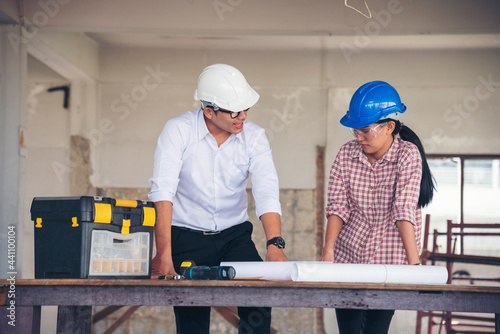 Construction engineer teamwork Safety Suit Trust Team Holding White Yellow Safety hard hat Security Equipment on Construction Site. Hardhat Protect Head for Civil Construction Engineer Concept