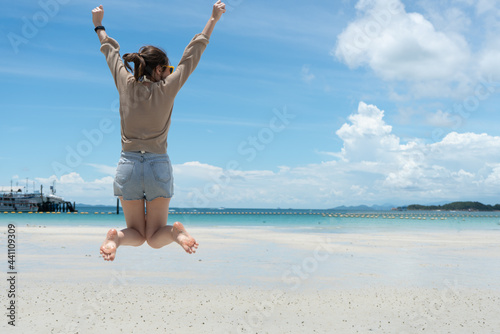 happy person jumping on the beach photo