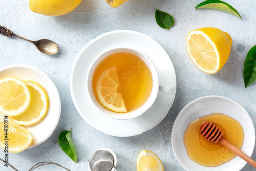 Lemon tea with honey, overhead flat lay shot. Organic lemons, green leaves and the natural remedy of the healthy beverage