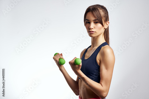 sportive woman with dumbbells in hands pumped up press fitness exercise gym