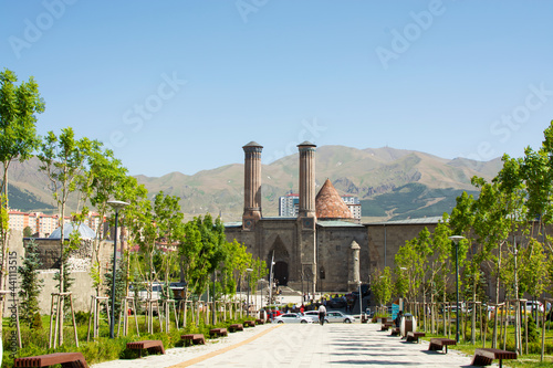 Erzurum,Turkey-June 19 2021: Double Minaret Madrasah and historical monuments and three vaults, Palandoken Mountain in the background.