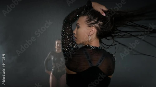 group of professional go-go dancers ladies is moving passionately at black background photo