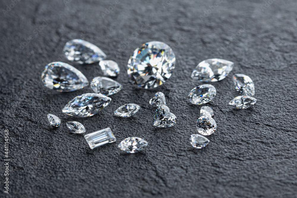Polished diamonds of various shapes and sizes at workplace of jewelry expert evaluating the quality of stones on dark background with copy space. High quality photo Polished diamonds of various shapes and sizes at workplace of jewelry expert evaluating the quality of stones on dark background with copy space. High quality photo