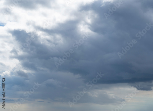 Abstract nature background, view of dense, heavy clouds and blue sky