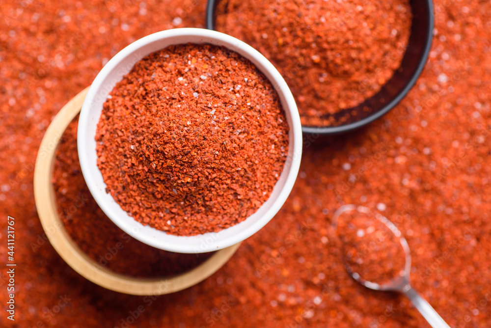 Red cayenne pepper, Chili flakes, Chili powder in a bowl with spoon, Top view Red cayenne pepper, Chili flakes, Chili powder in a bowl with spoon, Top view
