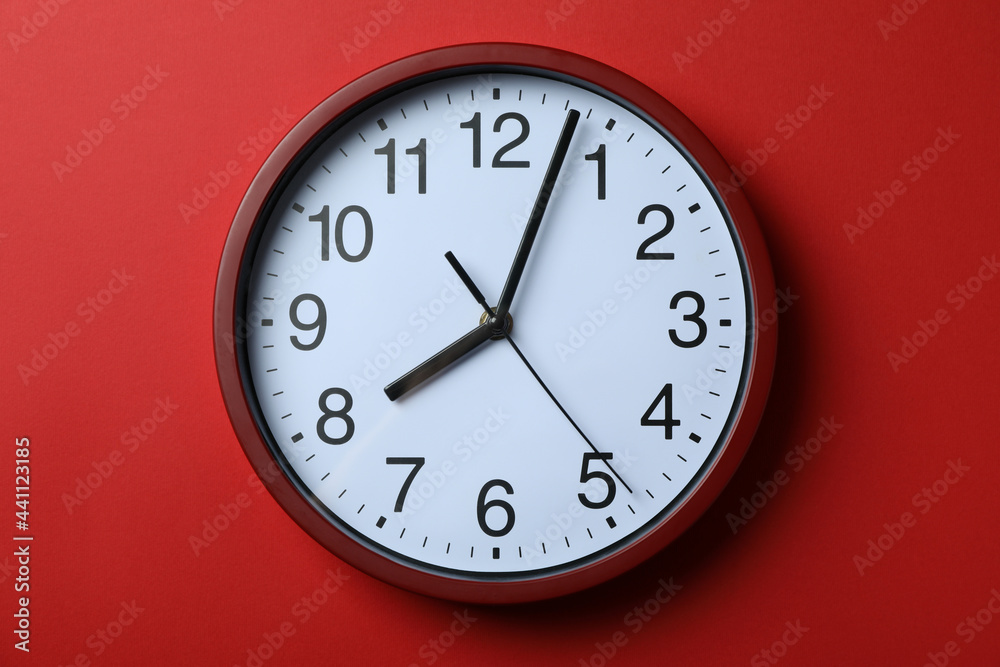 Standard red home clock on red background Standard red home clock on red background