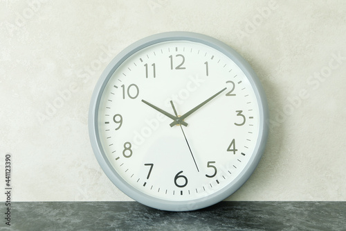 Standard gray clock against white textured background