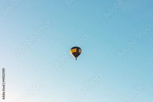 Hot Air Balloon on a blue sky.One Blue yellow hot air balloon in blue clear sky.Copy space.