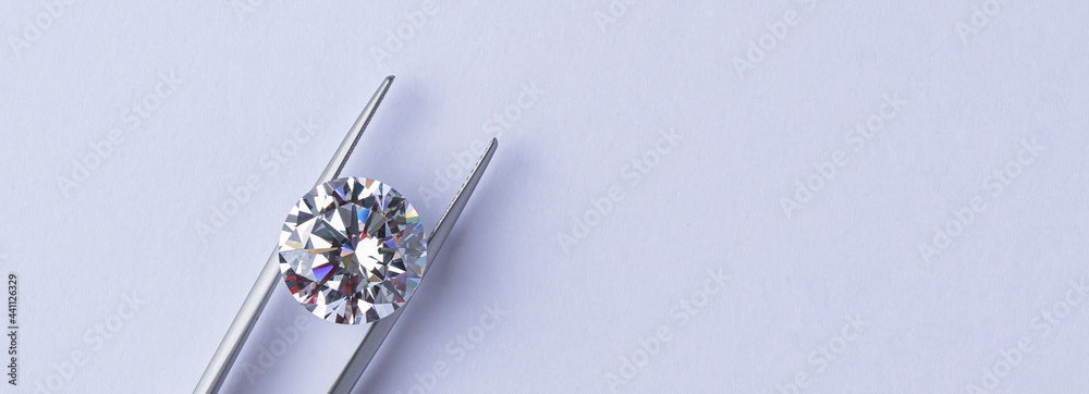 Polished diamonds of various sizes and shapes wit jewelry tools lie at the workplace of an expert examining the quality of stones on light background with copy space. High quality photo - obrazy, fototapety, plakaty 