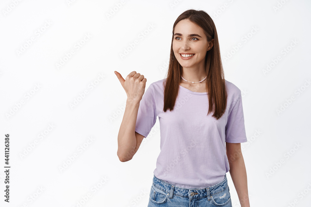 Image of young smiling woman pointing left, look at logo with hopeful dreamy face, watching something, reading promotional banner aside, white background Image of young smiling woman pointing left, look at logo with hopeful dreamy face, watching something, reading promotional banner aside, white background