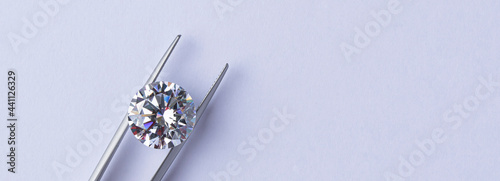 Polished diamonds of various sizes and shapes wit jewelry tools lie at the workplace of an expert examining the quality of stones on light background with copy space. High quality photo photo