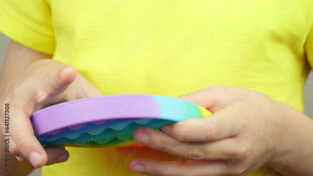 Toy pop it close-up. The hands of a small child press on the bubbles of a soft toy. A popular game for children's development. Antistress toy. Toy pop it close-up. The hands of a small child press on the bubbles of a soft toy. A popular game for children's development. Antistress toy.