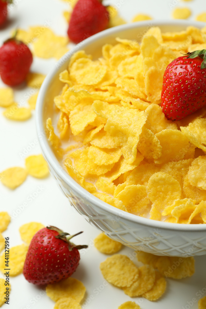 Concept of tasty breakfast with cornflakes and strawberry on white background Concept of tasty breakfast with cornflakes and strawberry on white background