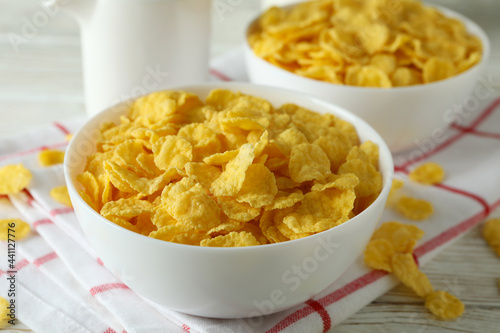 Concept of tasty breakfast with cornflakes on white wooden table