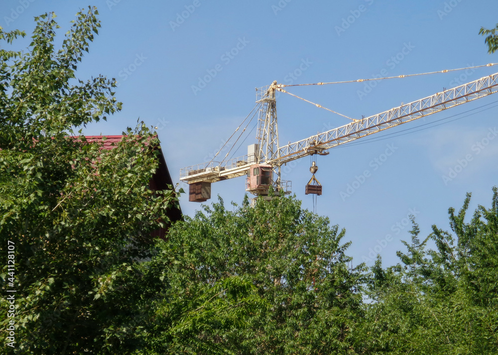 Building under construction. Kazakhstan (Ust-Kamenogorsk). Residential building. Urban grunge. New residential area. Construction site. Construction crane. Blue sky