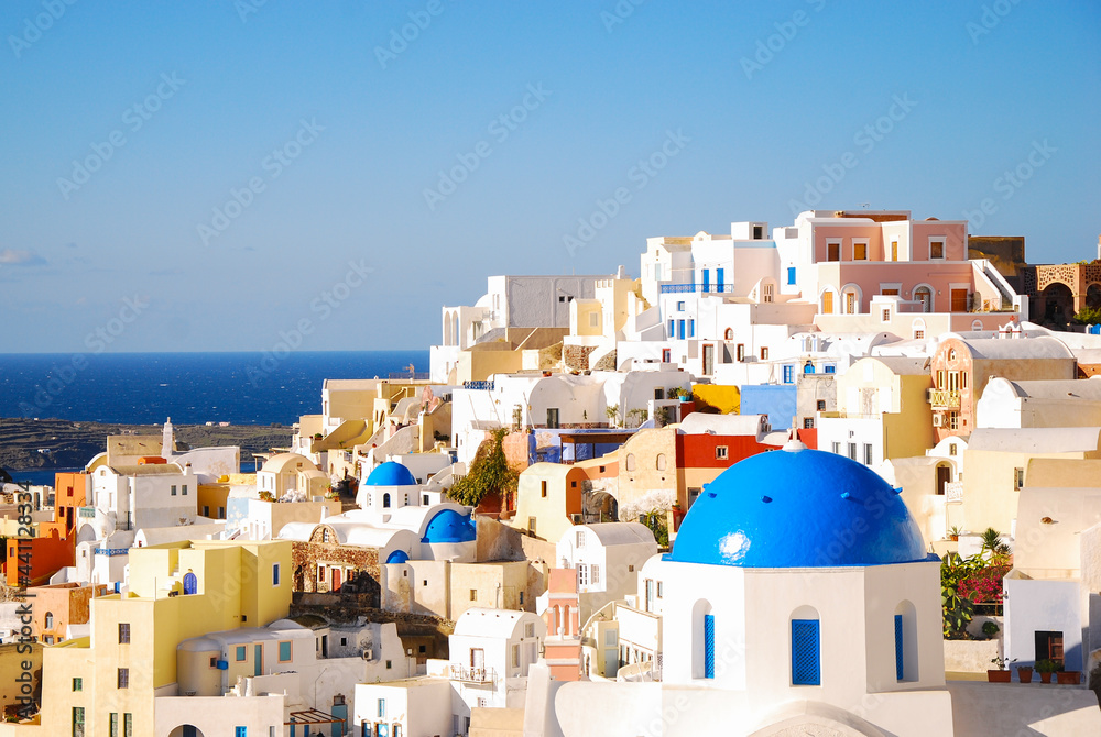 Scenic view of the white residential houses and church with blue dome. Oia, Santorini, Greece