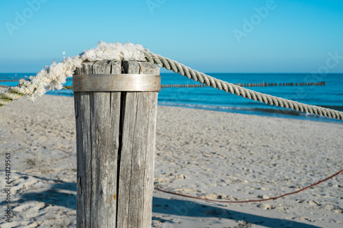 Fototapeta Naklejka Na Ścianę i Meble -  Wooden pole on the beach with rope. Beautiful and calm coastline at the Baltic Sea, Germany.