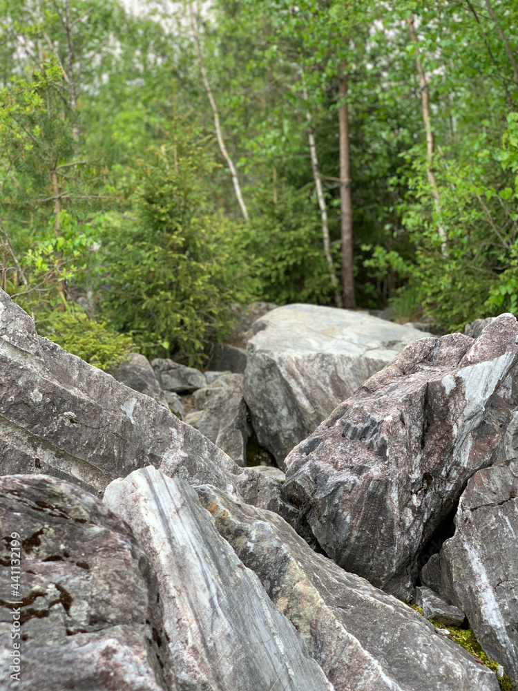 Marble boulders left over from marble mining in the Ruskeala Mountain Park on a sunny summer day. Marble boulders left over from marble mining in the Ruskeala Mountain Park on a sunny summer day.