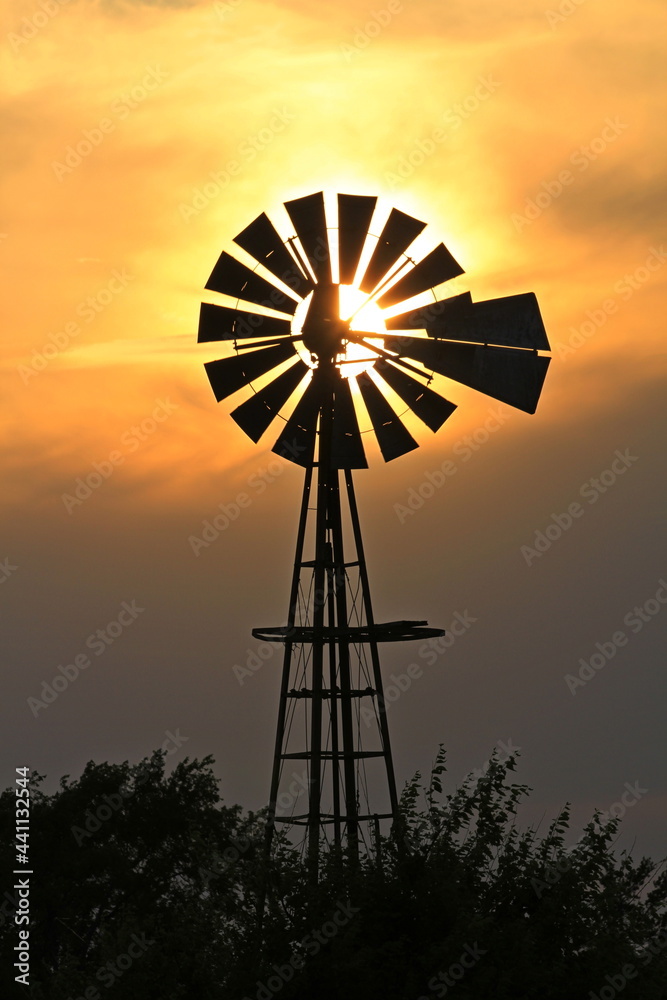 Kansas colorful Sunset with a Windmill silhouette and a colorful sky north of Hutchinson Kansas USA out in the country. Kansas colorful Sunset with a Windmill silhouette and a colorful sky north of Hutchinson Kansas USA out in the country.