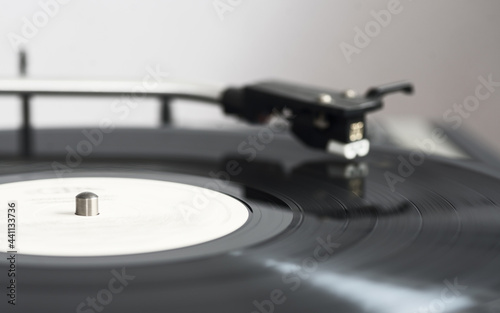 A spinning black vinyl record on a turntable. In motion. Selective focus.