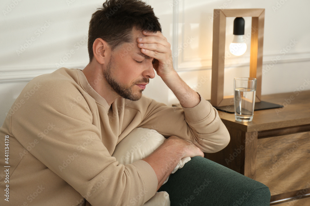 Man suffering from terrible migraine on sofa at home Man suffering from terrible migraine on sofa at home