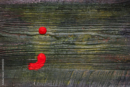 A semicolon punctuation mark painted in red paint on an old wooden board. photo