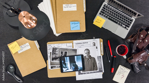 General view of the police detective's desk. The policeman is investigating.