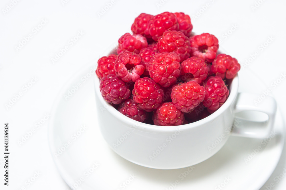 Raspberries in a cup on a white background. Red ripe raspberries close-up. Delicious berry Raspberries in a cup on a white background. Red ripe raspberries close-up. Delicious berry