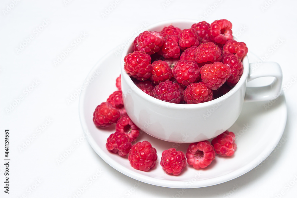 Raspberries in a cup on a white background. Red ripe raspberries close-up. Delicious berry Raspberries in a cup on a white background. Red ripe raspberries close-up. Delicious berry