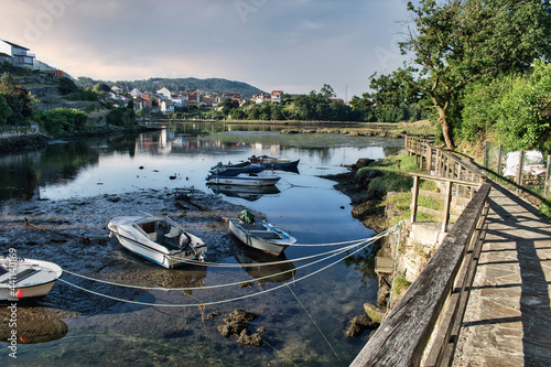 Pequeñas embarcaciones de recreo y pesca varadas y amarradas durante la marea baja en Ponte Sampaio, provincia de Pontevedra, España photo