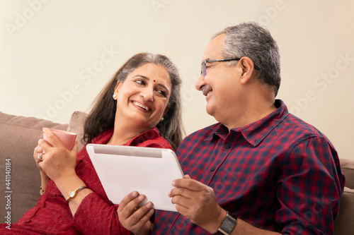 A HUSBAND AND WIFE SITTING TOGETHER AND HAPPILY LOOKING AT EACH