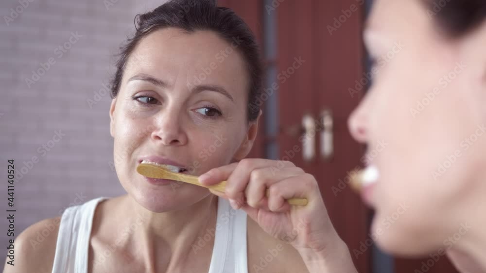Woman take care of teeth. A happy woman brush her teeth in the morning in the bathroom. Woman take care of teeth. A happy woman brush her teeth in the morning in the bathroom.