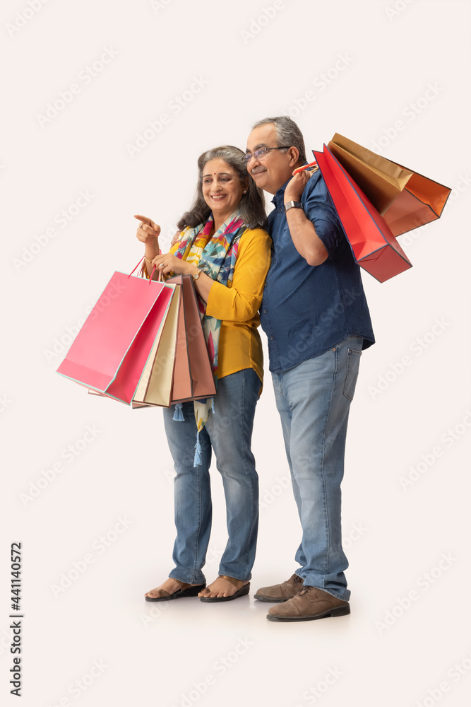 AN ADULT WOMAN HAPPILY POINTING WHILE SHOPPING WITH HUSBAND