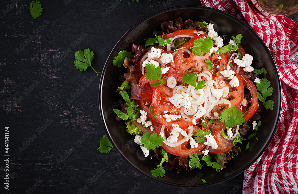 Vegetable salad with tomato, fresh lettuce, soft cheese and onion. Healthy diet food. Top view, above Vegetable salad with tomato, fresh lettuce, soft cheese and onion. Healthy diet food. Top view, above