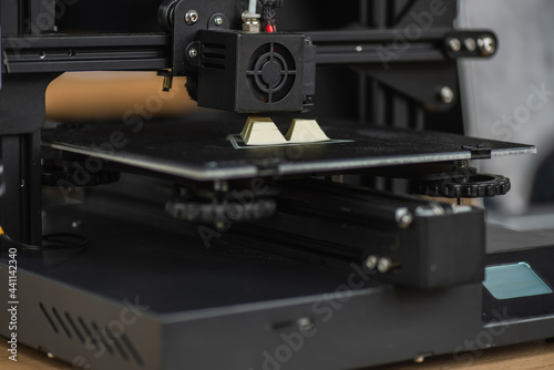 close up view of 3D printer creating plastic model on blurred background