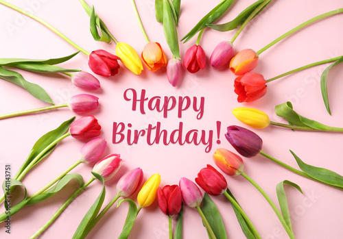 Happy Birthday! Heart made with beautiful tulips on pink background, flat lay