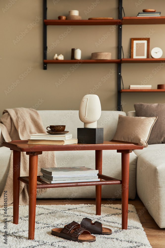 Stylish interior of living room with design wooden coffee table, beige sofa, cup of coffee, book, decoration and elegant accessories in stlish home decor. Template.