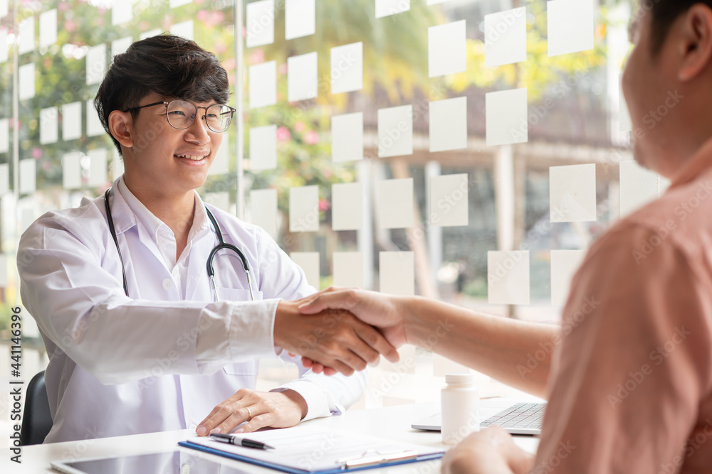 A male doctor and a male patient having a handshake after meeting the doctor’s appointment A male doctor and a male patient having a handshake after meeting the doctor’s appointment