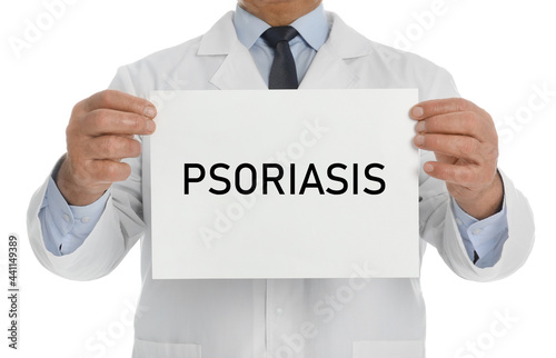 Doctor holding sign with word PSORIASIS on white background, closeup