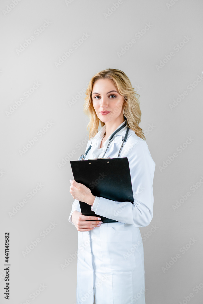 Portrait of young happy female doctor with kind face, with tablet in his hands, before medical examination. Looking at the camera. Portrait of young happy female doctor with kind face, with tablet in his hands, before medical examination. Looking at the camera.