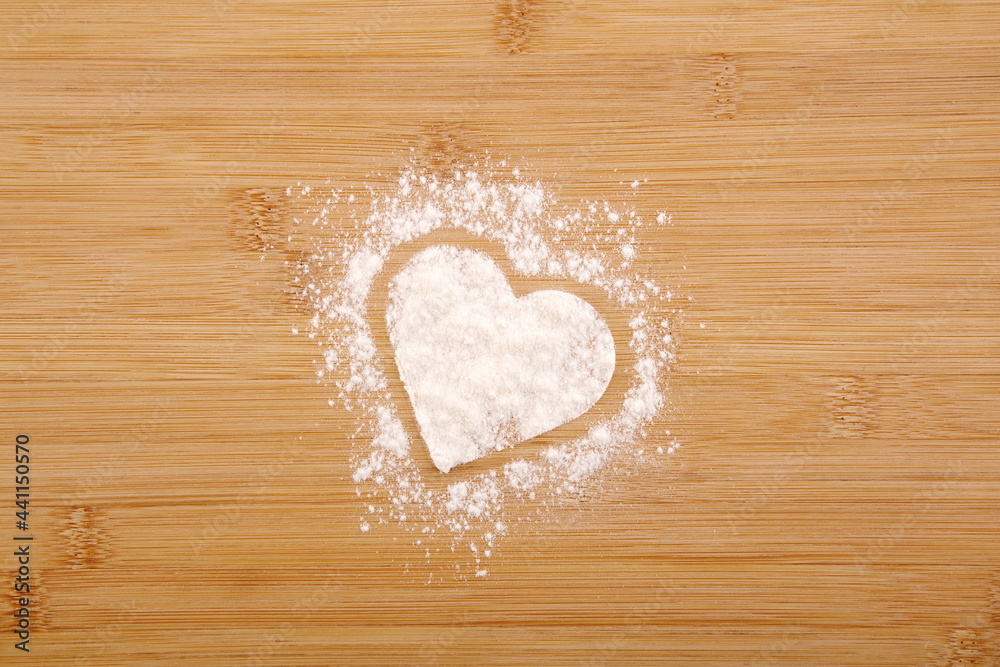 Obraz premium Heart made of flour on a wooden bamboo background