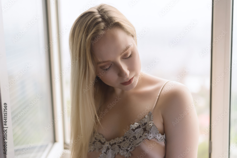 Sad young woman near window. Sad young woman near window.